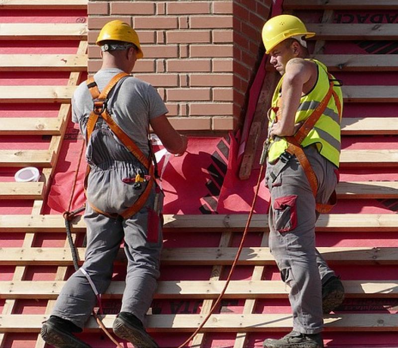 Local foundation repair contractors working on a tilting chimney.
